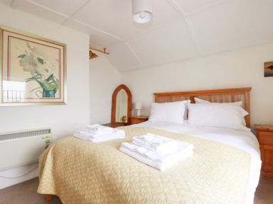 A bedroom with a bed and bedside furniture at Greeb Rocks Cottage Marazion