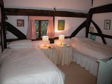 A bedroom with two single beds and bedside tables with lamps at The Yeoman's House in Bignor