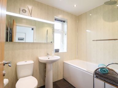 A bathroom with a bathtub and sink at Arnant in Dolgellau