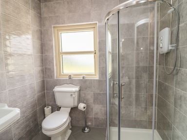 A bathroom with a toilet a window and a glass-enclosed shower at Dromstabla in Glencar