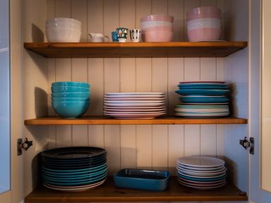 A cupboard with stacked bowls plates cups and a dish at The Schooner in Goleen County Cork