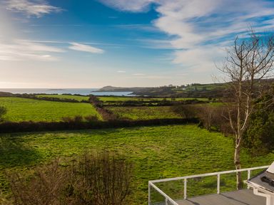 A view of green fields with a coastline and blue sky at The Schooner in Goleen County Cork