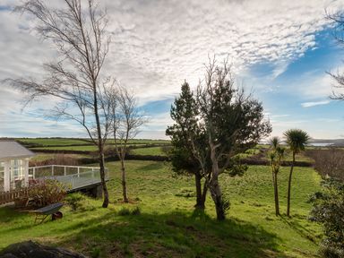 A grassy field with several trees near a house with a deck at The Schooner in Goleen County Cork