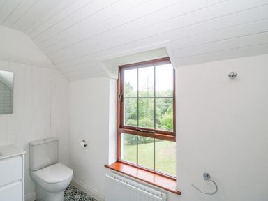 A bathroom with a toilet a window and a radiator at The Schooner in Goleen County Cork