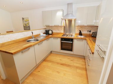 A kitchen with wooden countertops an oven a gas stove a sink and cabinets at 6 Streamside Lanreath