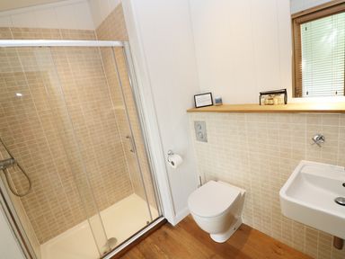 A bathroom with a shower stall toilet and sink at 6 Streamside in Lanreath