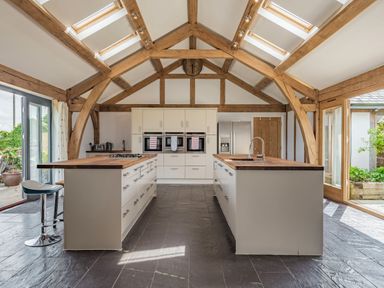 A kitchen with wooden beams two islands and built in ovens at Hen Hafod in Talwrn near Llangefni