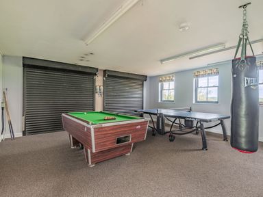 A game room with a pool table table tennis table and a punching bag at Hen Hafod in Talwrn near Llangefni