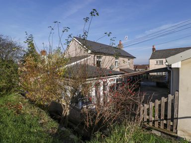 A view of a residential area with houses bushes and a wooden fence at Rose Cottage in Bream