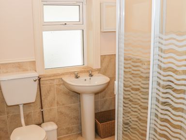A bathroom with a toilet sink window and shower at Cnoc suan in Aughavas County Leitrim