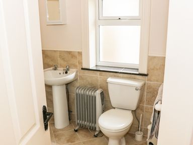 A bathroom with a toilet sink radiator and window at Cnoc suan in Aughavas County Leitrim