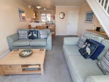 A living room with a coffee table and sofas at Daisy Lodge in Norwich
