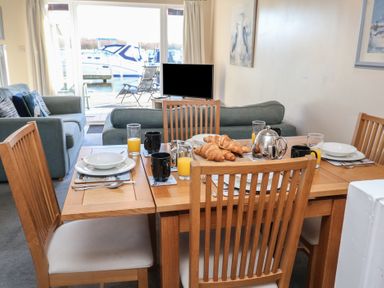 A dining area with a table set for breakfast at Daisy Lodge in Norwich
