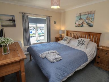 A bedroom with a bed and a desk at Daisy Lodge in Norwich