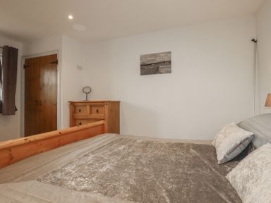 A bedroom with a bed and dresser at The Smithy in Blisland