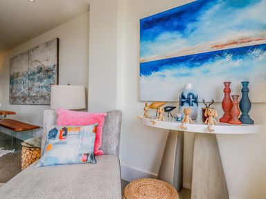 A corner of a room with a chaise lounge and decorative items on a console table at Stargazers in Sennen