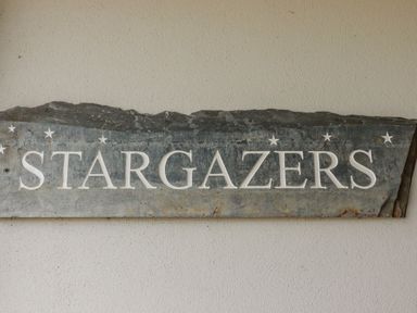 A stone slate with the word Stargazers carved on it and stars above the letters on a wall at Stargazers in Sennen