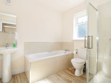 A bathroom with a bathtub a toilet a sink and a shower at Aln in Longframlington