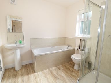 A bathroom with a pedestal sink a bathtub a toilet and a glass shower enclosure at Breamish in Longframlington