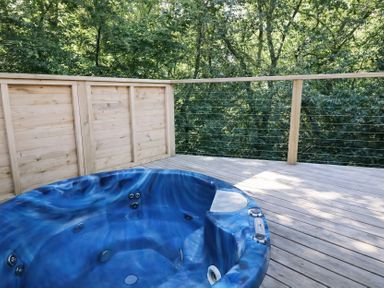 An outdoor space with a hot tub on a wooden deck at 2 Streamside in Lanreath
