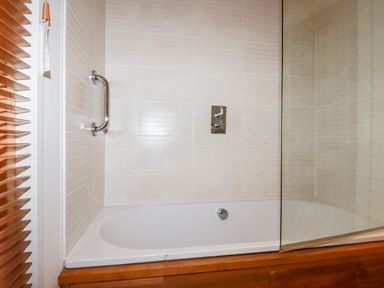 A bathroom with a bathtub shower and glass screen at 2 Stonerush Valley in Lanreath
