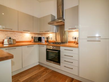 A kitchen with wood countertops built-in oven microwave toaster and wooden floor at 9 Stonerush Valley in Lanreath