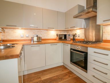 A kitchen with wooden countertops stainless steel oven gas stove and microwave at 9 Stonerush Valley in Lanreath