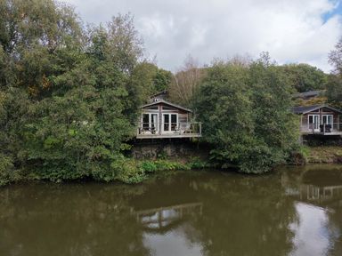 Two houses near a river with trees at 2 Water's Edge in Lanreath