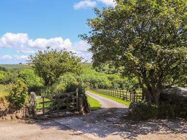 A country road with wooden gate trees and green fields at Sunbury Barn in St Agnes
