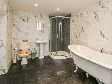 A bathroom with a toilet a pedestal sink a shower enclosure and a clawfoot bathtub at C S Lewis Balcony in Lynton