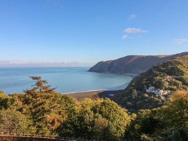 A coastal landscape with trees and houses near hills by the sea at C S Lewis Balcony in Lynton