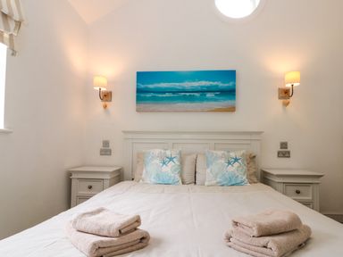 A bedroom with a bed and folded towels on it at Sea Breeze in The Bay near Filey