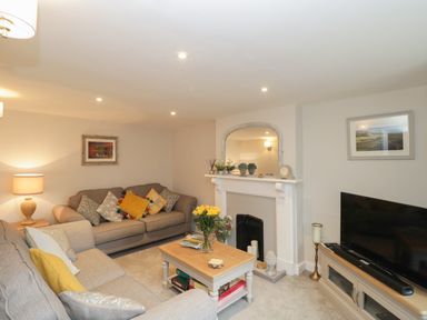 A living room with two sofas a coffee table and a television at Market House in Abbotsbury