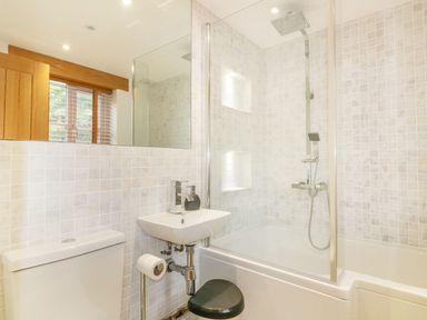 A bathroom with a toilet sink shower bathtub and window at Crift Farm Cottage Lanlivery near Lostwithiel