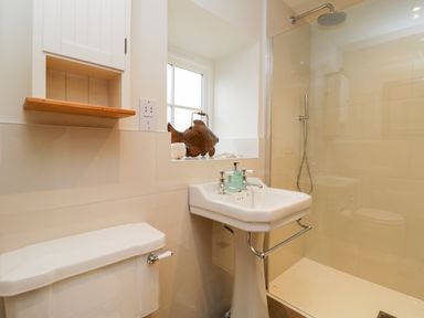A bathroom with a toilet sink shower and a window at Wallerthwaite Barn Cottage in Markington