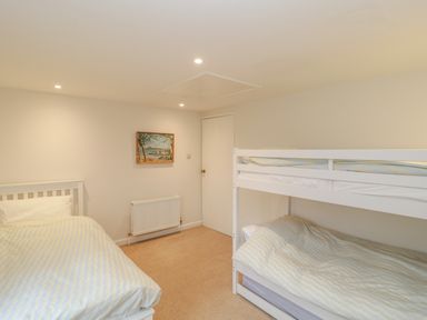 A bedroom with a single bed and a bunk bed a radiator and a painting on the wall at Church View in Salisbury