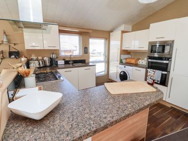 A kitchen with a stove sink washing machine microwave and oven at Percy Wood Country Park Swarland