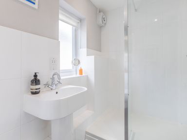 A bathroom with a white sink and a shower enclosure at Beach Retreat in Instow