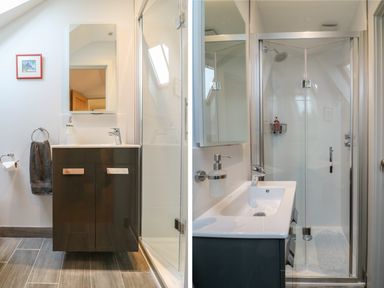 A bathroom with a sink, mirror, towel ring with a towel, toilet paper holder, and a glass-enclosed shower at Lantern Cottage in Padstow