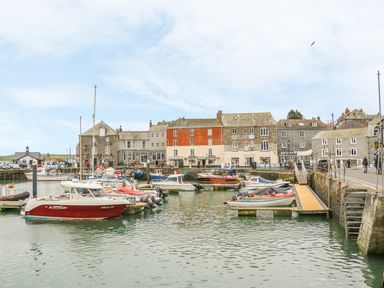 A harbor with boats docked and buildings in the background at Lantern Cottage in Padstow