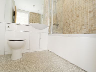 A bathroom with a toilet sink and bathtub with tiled walls at Orchard Cottage in Shaftesbury