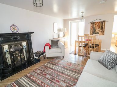 A living room with a fireplace sofa armchair dining table and chairs at Cranny Corner in Carnlough