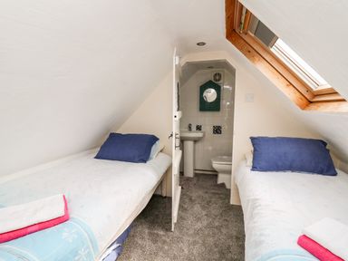 A small attic bedroom with two single beds and a skylight window at The Hen Pen in Star near Cenarth
