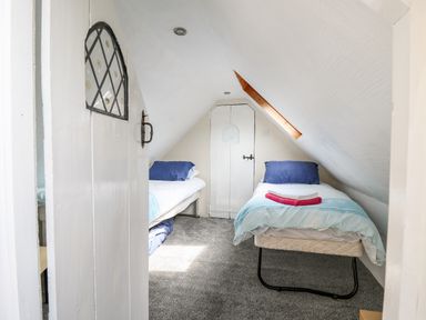 A small bedroom with two single beds and a slanted ceiling at The Hen Pen in Star near Cenarth