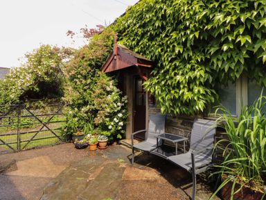 An outdoor area with chairs and a table near a door at Holemire Barn in Lorton