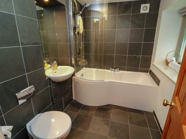 A bathroom featuring a bathtub, sink, and toilet at Holemire Barn in Lorton