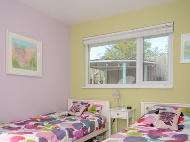 A bedroom with two single beds a nightstand with a lamp and a window at Coastal Haven in Crackington near Crackington Haven