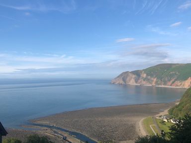 A coastal view of a bay with cliffs and a shoreline at The Penthouse Lynmouth Bay in Lynton