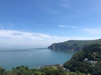 A coastal landscape with hills and houses by the sea at The Penthouse Lynmouth Bay in Lynton