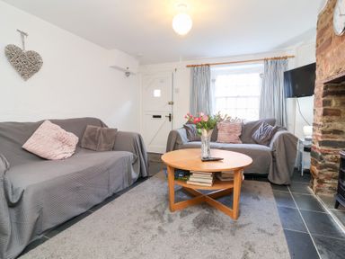 A living room with a sofa and coffee table at Willets Cottage in Appledore